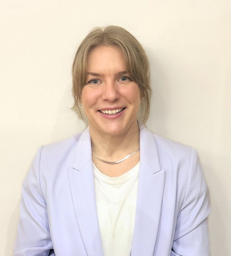 A photo of Dr Emily Porter, who has blonde hair tied up, she is smiling