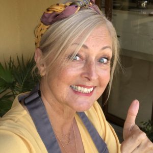 A photo of Julie. She has blue eyes and blonde hair and is smiling at the camera giving a thumbs up