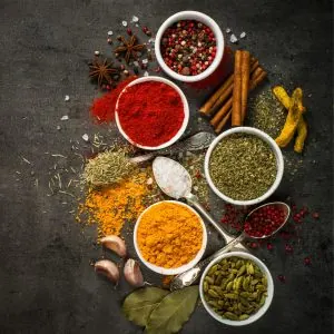 Photo of an arrangement of spices placed in small bowls and spoons and spread across a table