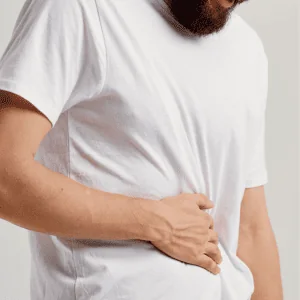 Photo of a man hunched holding onto his stomach in pain