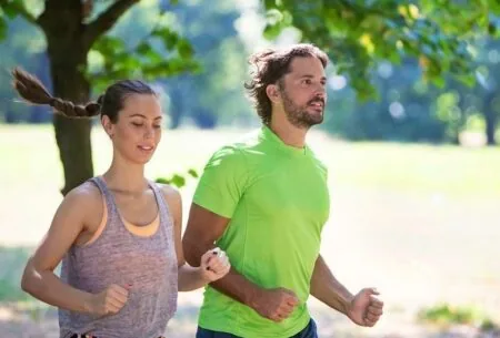 A man and a woman running together outside