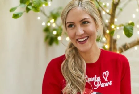 Megan Rossi pulling a cracker with a christmas jumper on