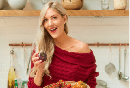 Dr Megan Rossi standing in a kitchen holding a large bowl of mixed vegetables