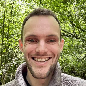 A photo of David smiling, he has short hair and blue eyes