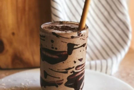 A photo of the super six coffee smoothie with a straw in it