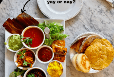 Platter of snacking foods set on a kitchen bench, including some mock meat with a title reading 'mock meat, yay or nay?'